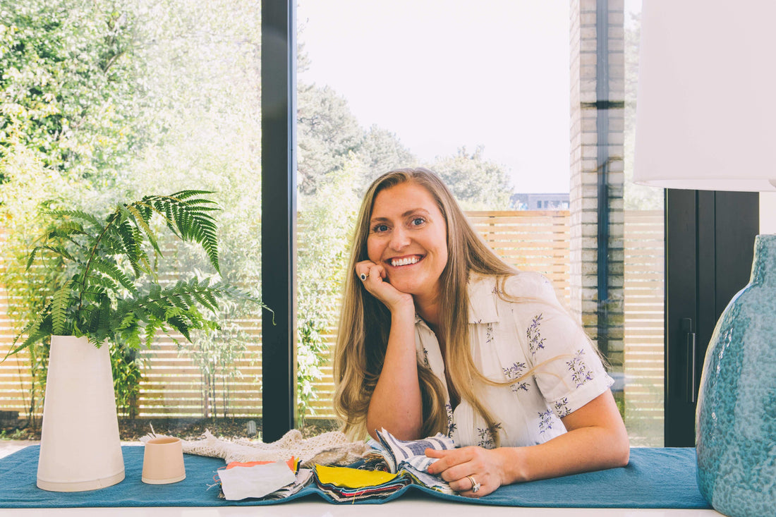 Image of founder and designer at Taylor & Gray, Jessica Brickenden, sitting in a kitchen of an architect designed house in Dublin, Ireland.